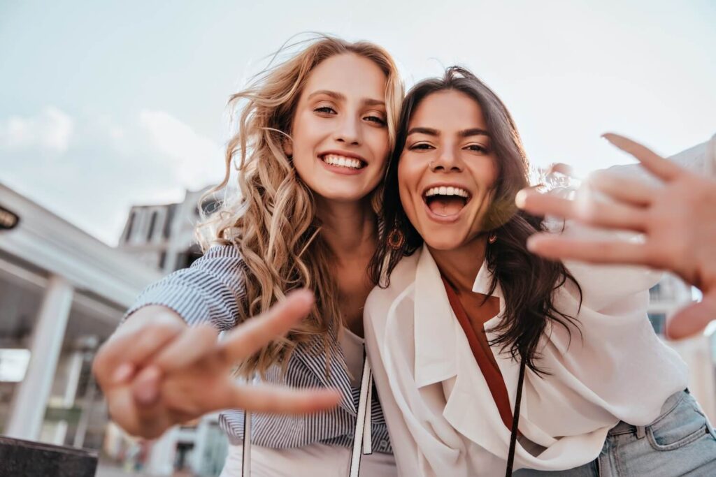 Two girls hugging while on vacation in the city.