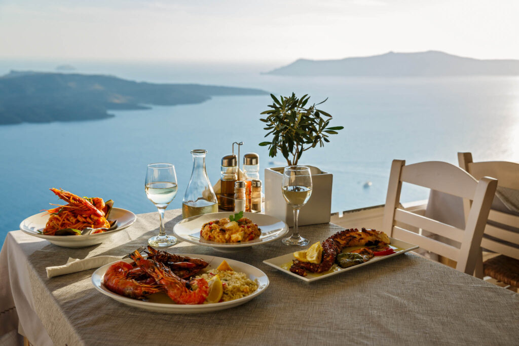 Gourmet seafood and wine enjoyed at a seaside table with sweeping ocean views — inspired by luxury travel experiences in the Mediterranean.